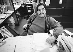 Jose Yabara with a desk full of paper looking upset