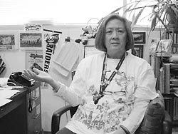 Margaret Leong sitting at desk jesturing
