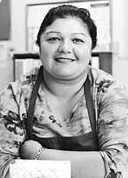 Linda Rodriguez smiling wearing an apron