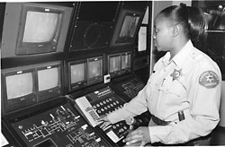 Kay Johnson looking at a bank of security monitors