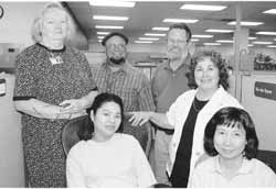 Group of social workers standing in the office by a partition