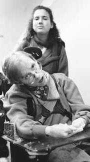 Diana Temkin pushing a wheel chair with Peter in it.