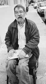 Charles Houck traveling down the street in his wheelchair