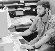 Social worker Randy Morris working at computer looking tense.