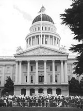 California State capitol with demonstrators marching infront of the building