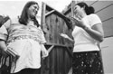 Monica listens as intern Pam Lee jestures. They are outside in a court yard