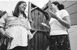 Pam and Monica engaged in a lively conversation out side in the yard.