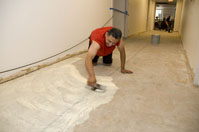 carpet layer spreading glue on floor