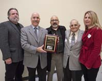Group of People on stage with plaque