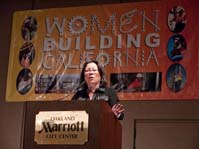 Patricia Shiu speaking at podium with Women Building California banner in background